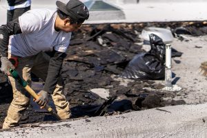 Four Twelve roofer shoveling debris